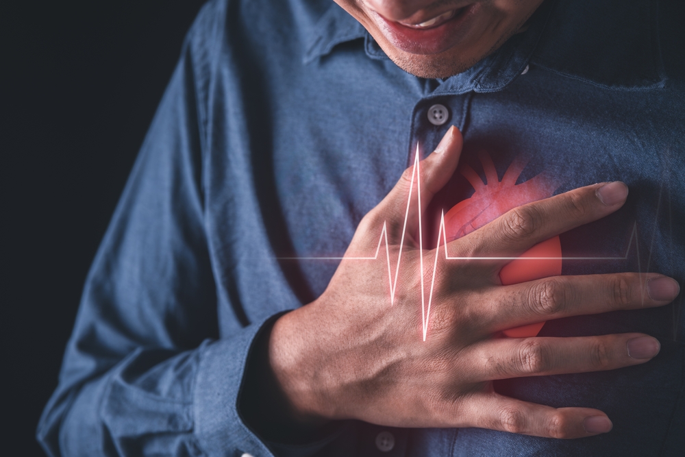 Man clutching his heart - Heart attack and cardiovascular health concept