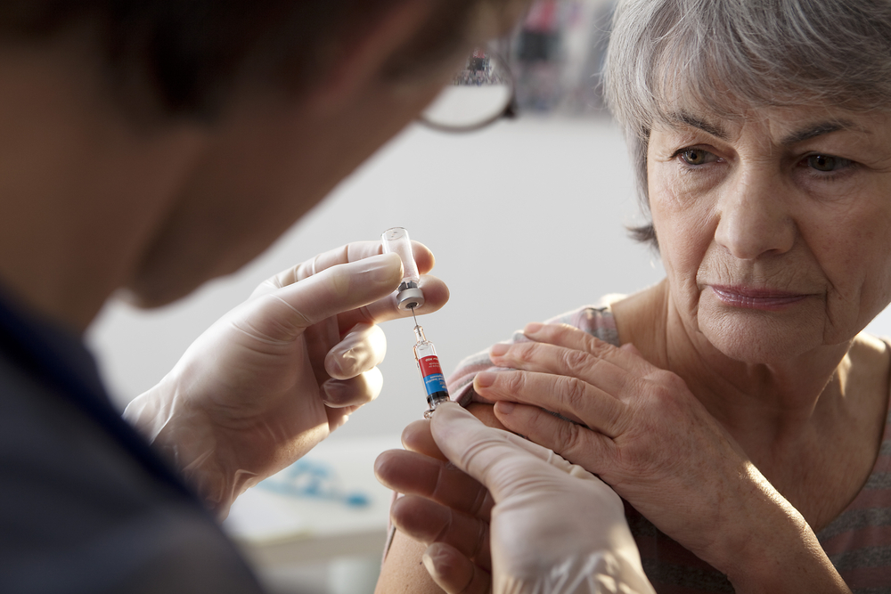 doctor vaccinating an elderly person with the flu vaccine